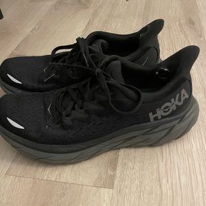Women’s all black Hoka shoes.